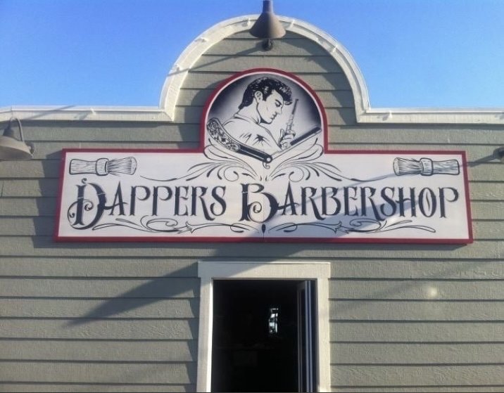 The Dappers Barbershop storefront and its illustrated vintage sign on West College Avenue